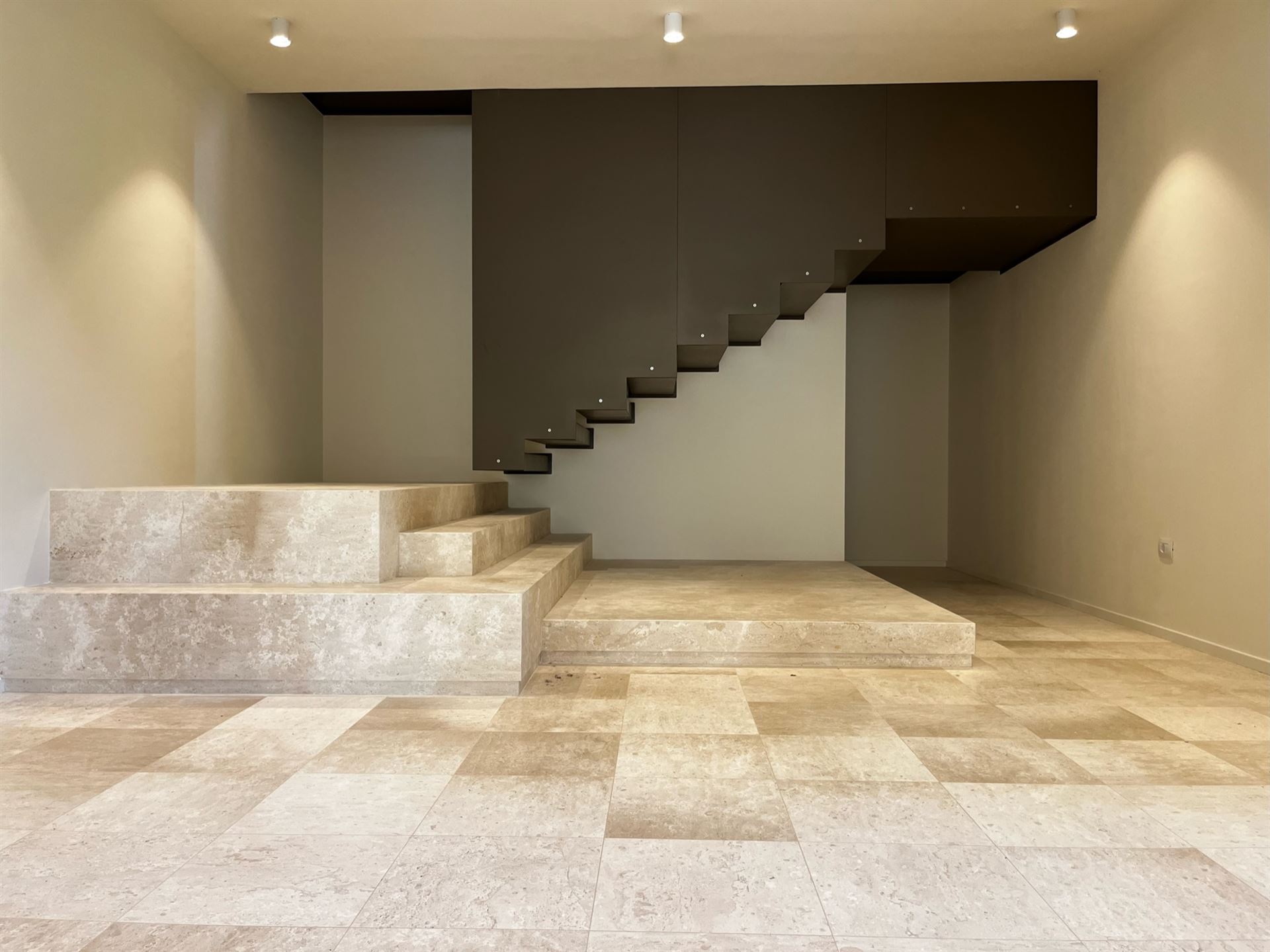 Interno realizzato da Arching srl — scala in cemento e illuminazione d'ambiente